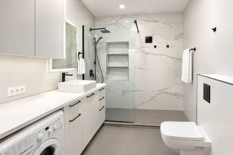 Modern bathroom with a walk-in shower and white furniture. - image 14
