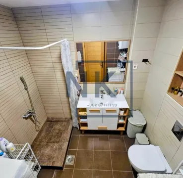 Compact bathroom with a shower enclosure, washbasin, and toilet. - image 10