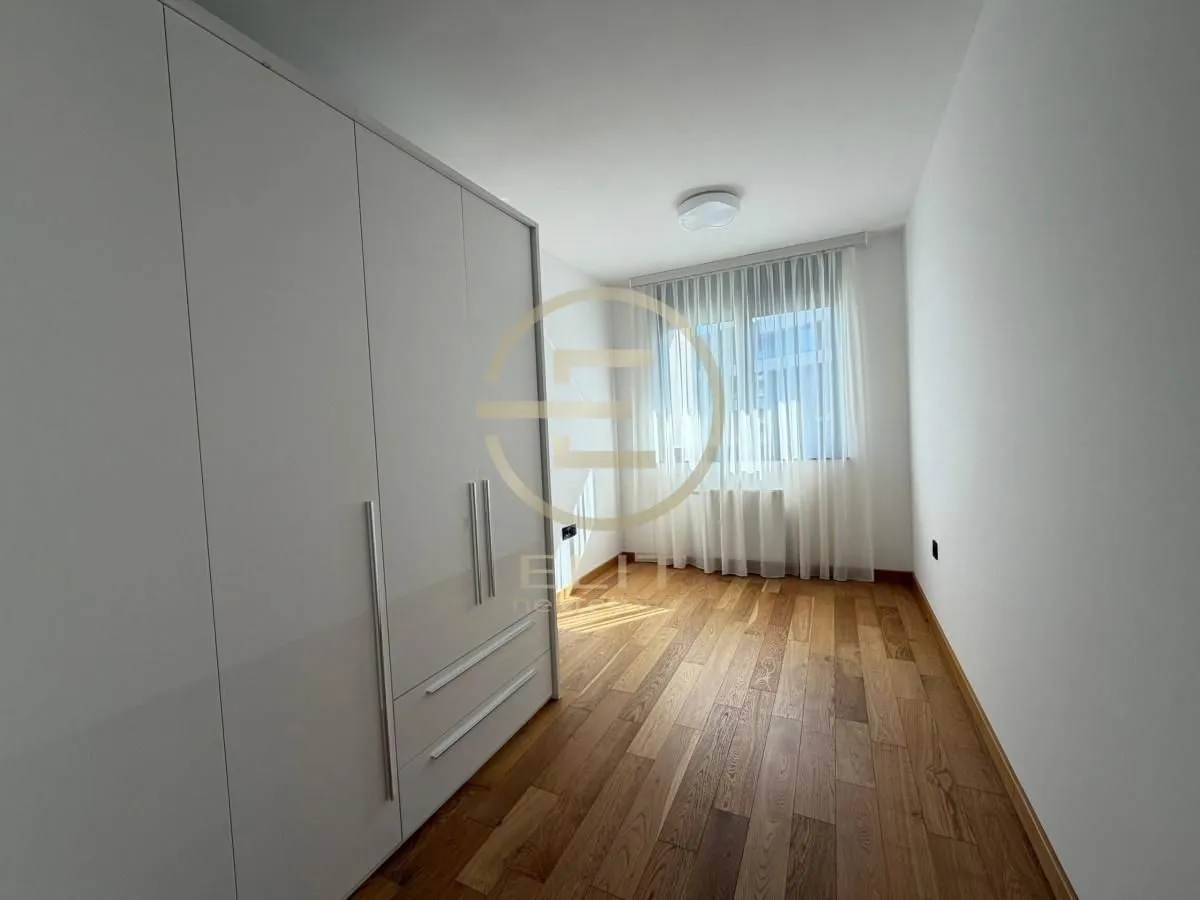 Empty bedroom with a large fitted wardrobe and hardwood flooring.