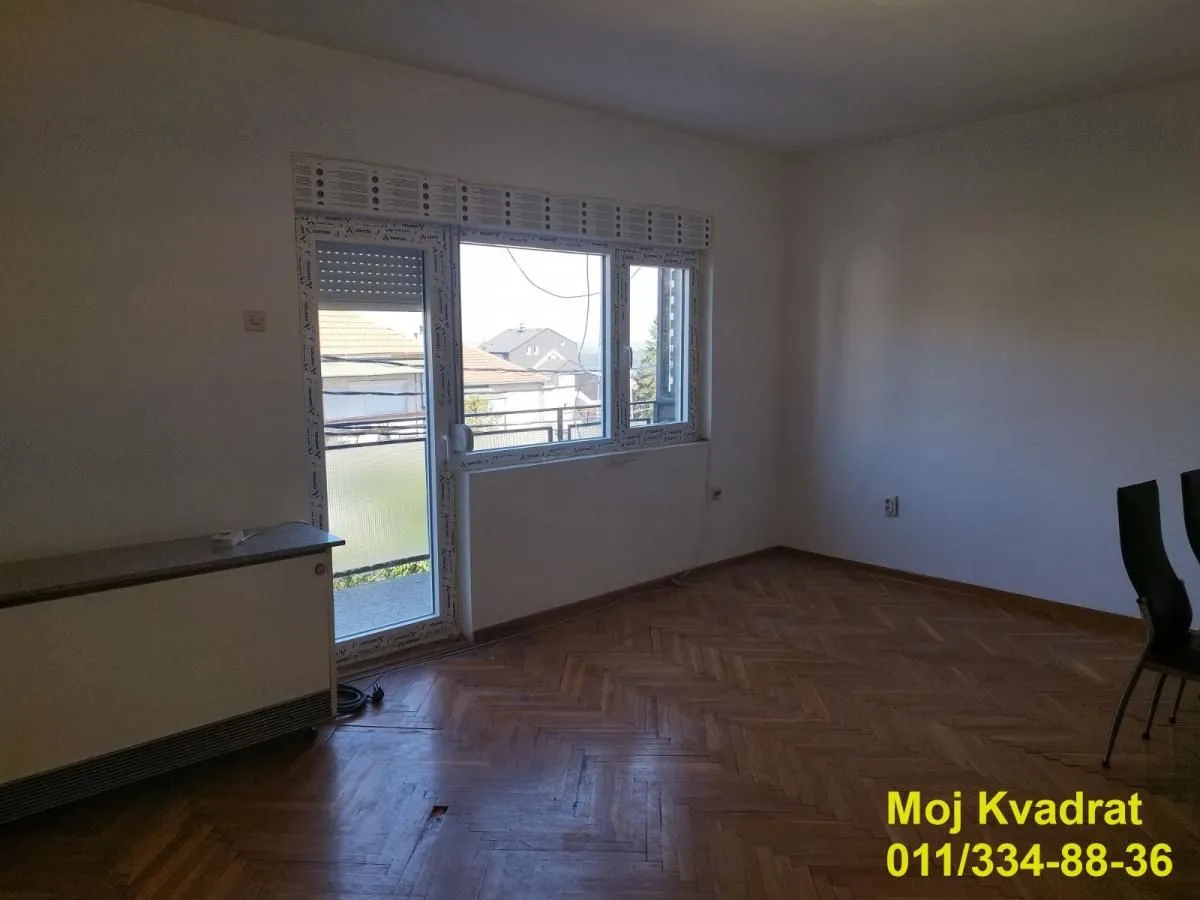 Empty room with parquet flooring and balcony access.