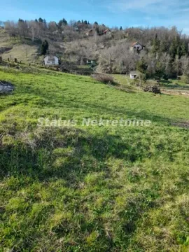 Zelena parcela sa pogledom na brdoviti pejzaž i okolne kuće. - image 12