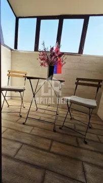 Zastakljena terasa sa stolom, stolicama i ukrasnim cvećem. - image 18
