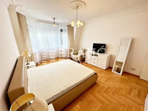 Spacious bedroom with a double bed, white dresser, and large windows. - image 6