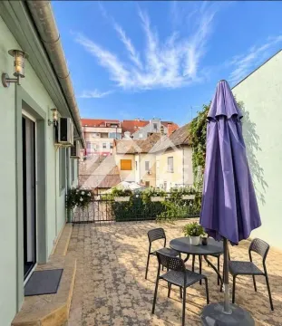 Spacious terrace with outdoor seating and a view of the surrounding buildings. - image 8
