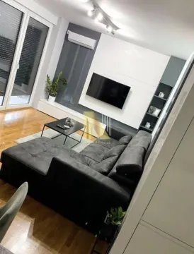 Moderna i uredna dnevna soba sa ugaonom garniturom i televizorom. - image 3