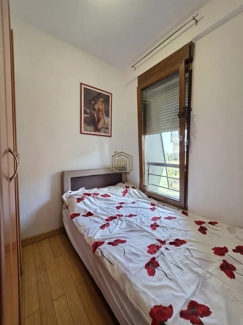 Small bedroom with a bed and a window overlooking the outside.