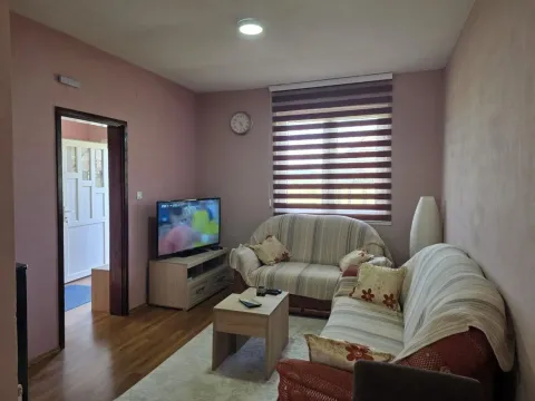 Dnevna soba sa garniturom, televizorom i pogledom na prozor. - image 3