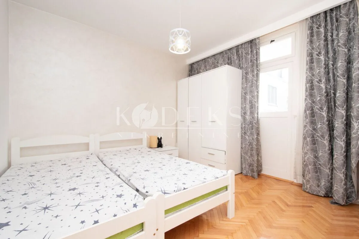Children's bedroom with two beds, wardrobe, and access to the terrace.