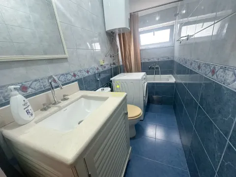 Manje kupatilo sa plavim pločicama, umivaonikom i kadom. - image 8