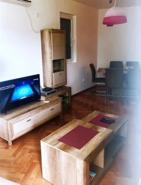 Svijetla dnevna soba sa drvenim namještajem i trpezarijom. - image 9