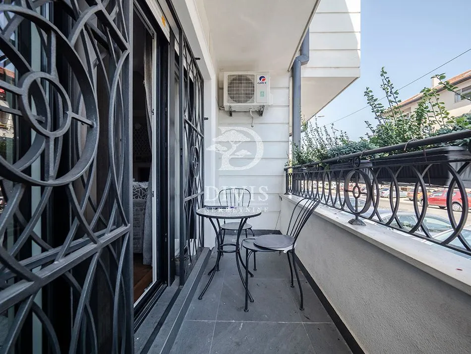 Namješten balkon sa garniturom za sedenje i ukrasnim ogradama.