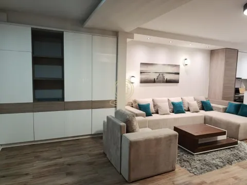 Spacious living room with a sectional sofa, armchair, large built-in wardrobe, and coffee table. - image 3