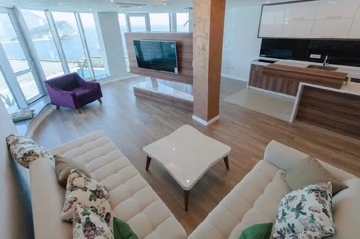 Spacious living room connected to the kitchen, with large windows and a sea view.