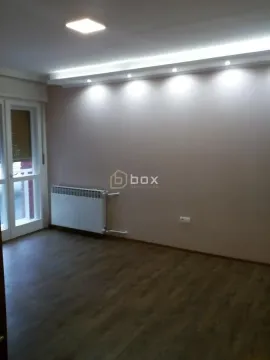 Empty room with parquet flooring, a radiator, and a drop ceiling with recessed lighting. - image 12