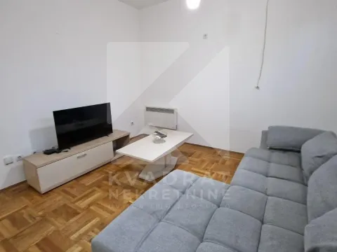 Dnevna soba sa ugaonom garniturom, televizorom i parketom na podu. - image 2