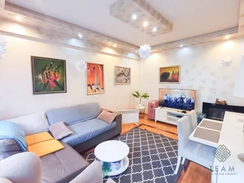 Living room with a sofa, TV, and dining table. - image 3