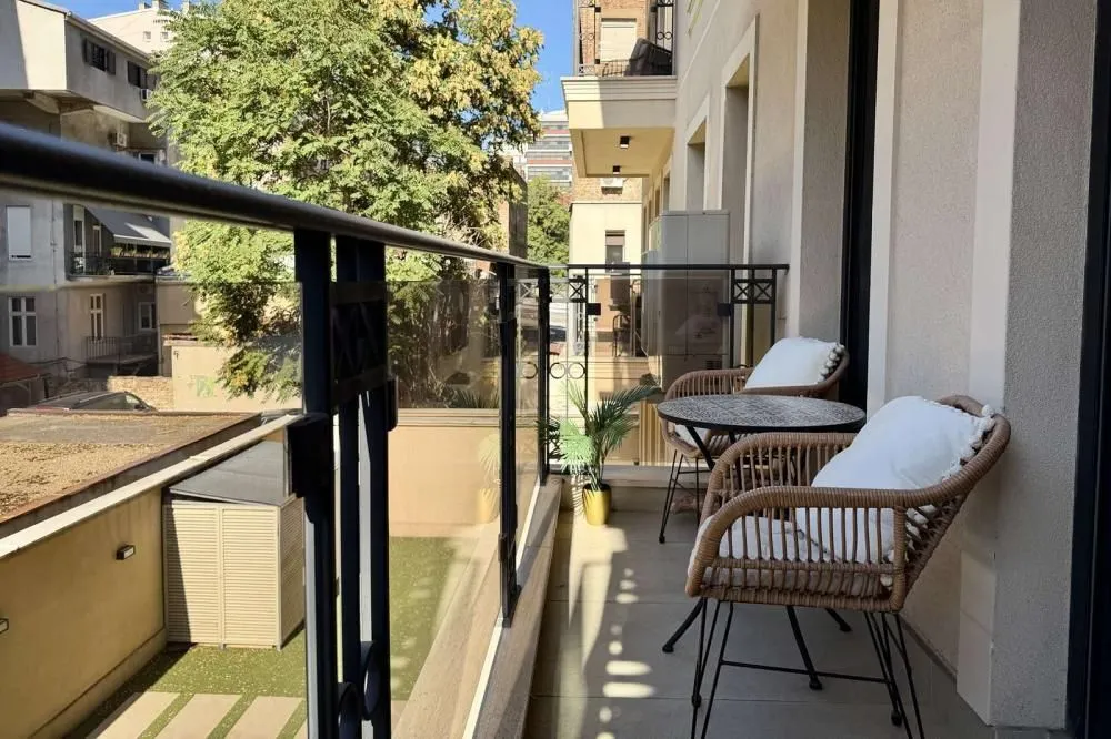 Udoban balkon sa garniturom za sedenje i pogledom na grad.