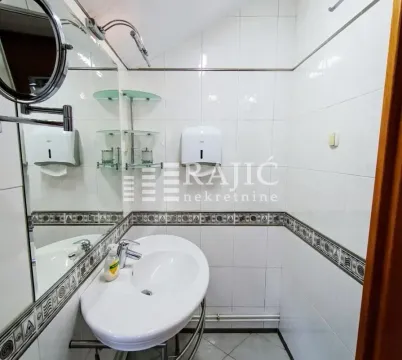 Small bathroom with a sink, mirror, and white tiles. - image 3