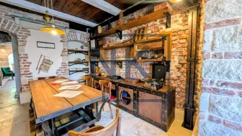 Rustic living room with a wooden table, exposed brick wall, and unique furniture. - image 8