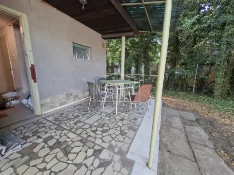 Natkrivena terasa sa stolom i stolicama ispred kuće. - image 7