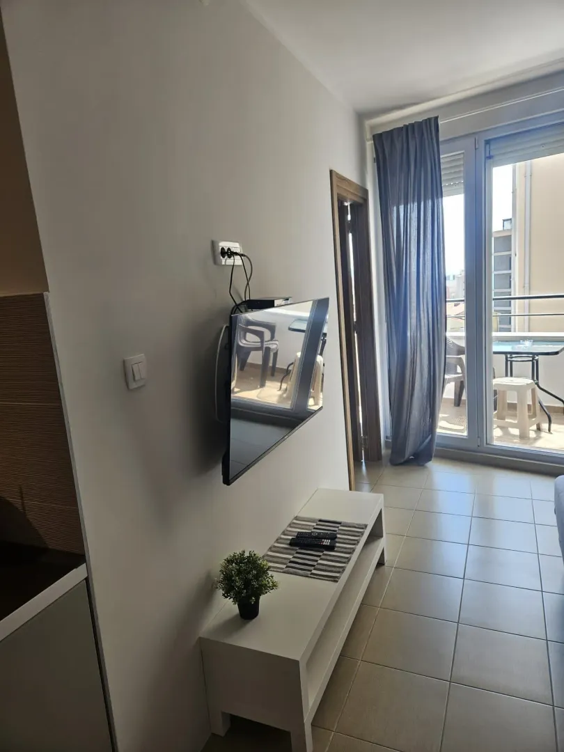 Living room with a wall-mounted TV and access to the terrace.