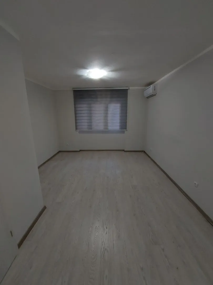Prazna soba sa svijetlim podom i klima uređajem.