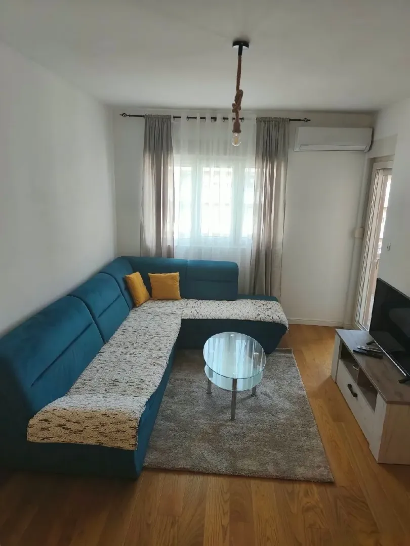 Living room with a blue corner sofa, coffee table, and television.