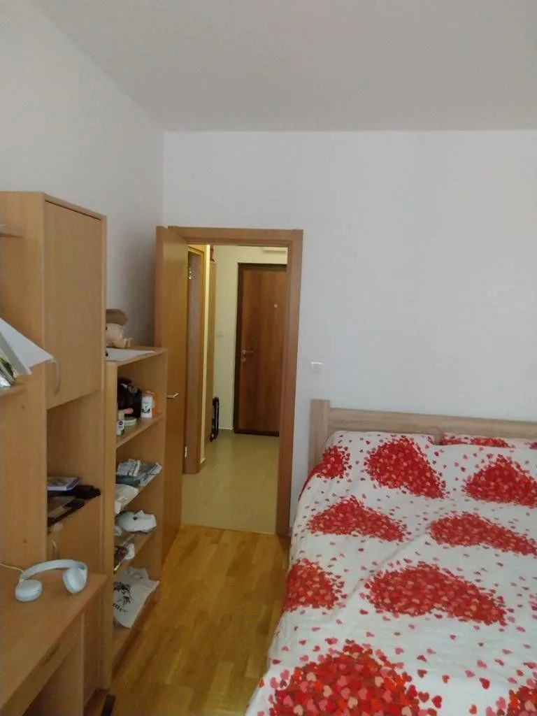 Furnished bedroom with a double bed and wooden furniture.