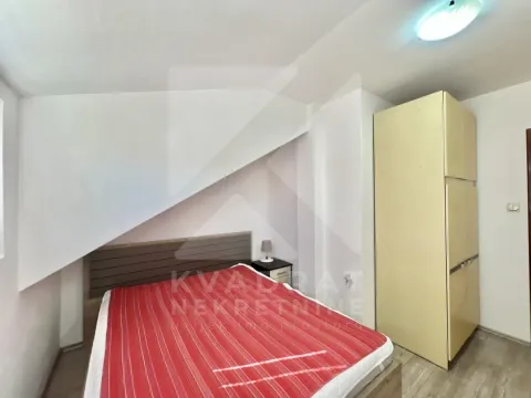 Small bedroom with a bed and wardrobe under the sloped ceiling. - image 6