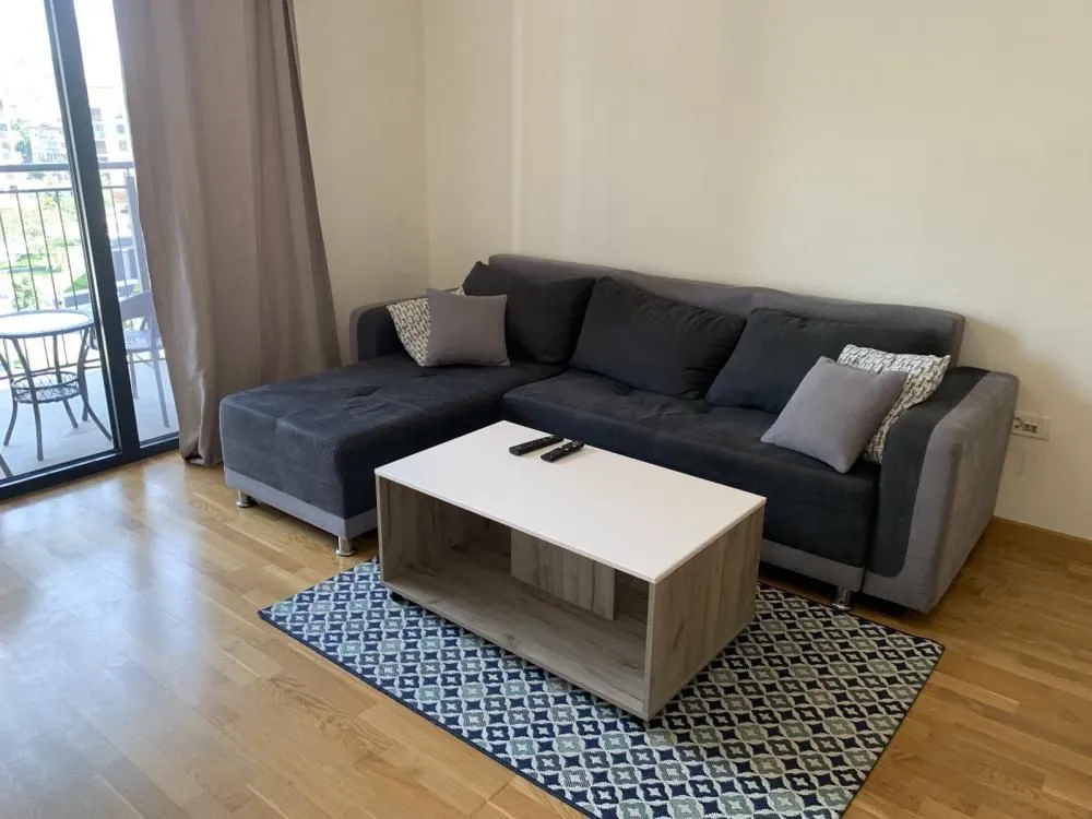Living room with a sectional sofa, coffee table, and access to the terrace.