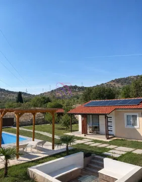 View of the house yard with a swimming pool and solar panels on the roof. - image 16