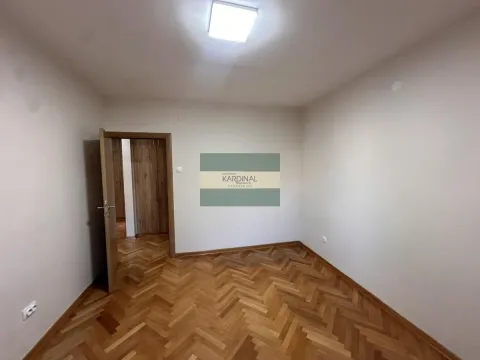 Empty room with parquet flooring and an open door leading to the hallway. - image 10