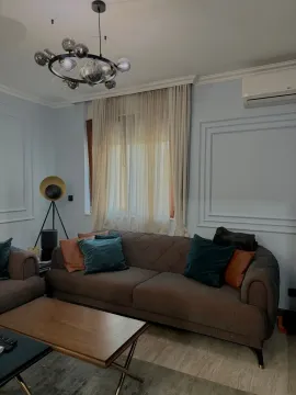 Dnevna soba sa garniturom, stočićem i modernim lusterom. - image 2