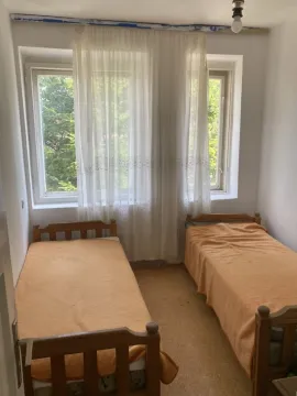 Small bedroom with two wooden beds and a window. - image 6