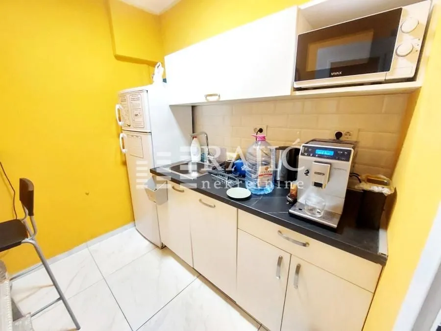 Small kitchen with light-colored cabinets and appliances.