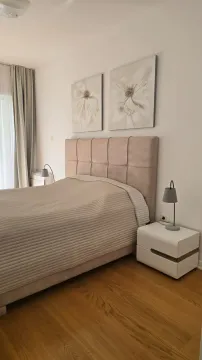A furnished bedroom with a double bed, nightstands, and wall art. - image 9