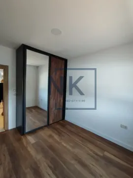 Smaller room with wooden flooring and a built-in wardrobe with a mirror. - image 11