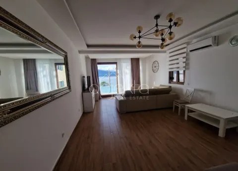 Living room with a sofa, large mirror, and sea view. - image 3