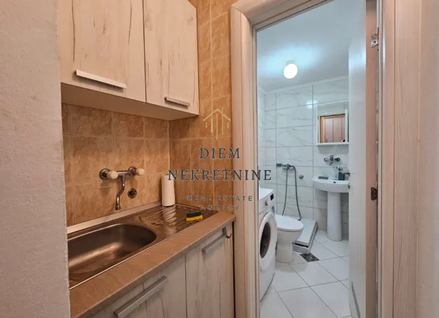 View from the kitchen towards the bathroom with a washing machine.