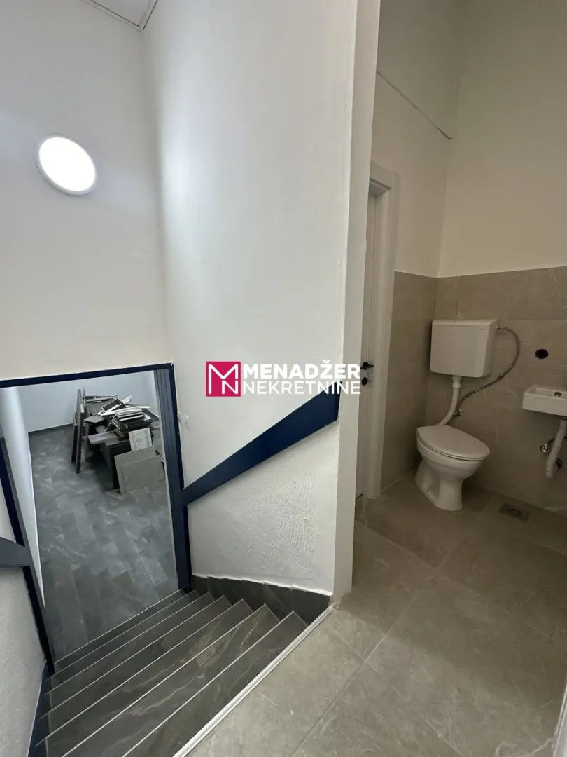 Small bathroom with toilet next to the stairs.