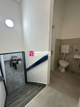 Small bathroom with toilet next to the stairs. - image 4