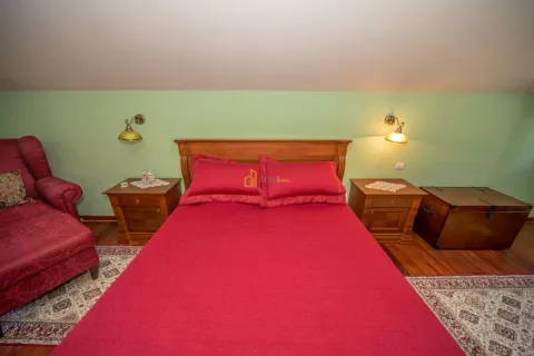 Bedroom with a double bed, bedside tables, and red bedding. - image 3