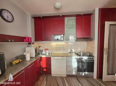Kuhinja sa crvenim elementima, sudoperom i ugrađenom šporetnom tehnikom. - image 9