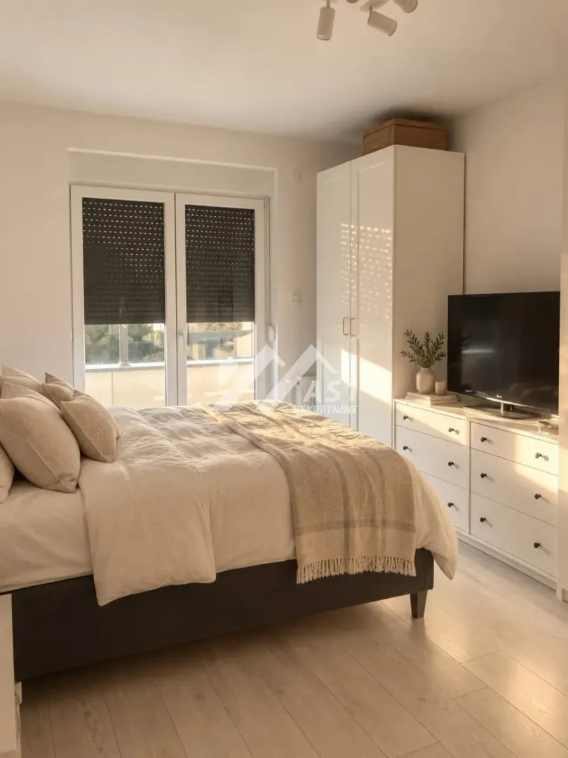 Furnished bedroom with a double bed, wardrobe, and TV chest of drawers.