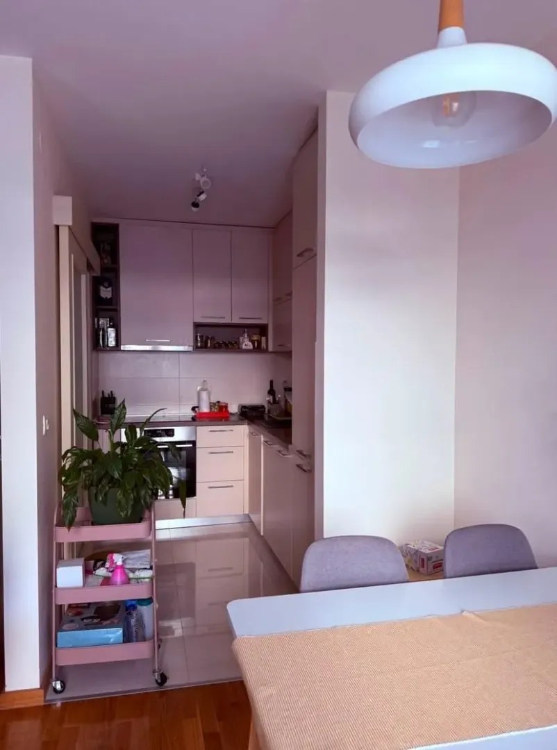 Small kitchen with light-colored cabinetry and an adjoining dining table.