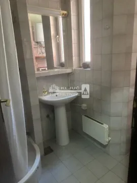 Manje kupatilo obloženo keramičkim pločicama sa umivaonikom i kadom. - image 18