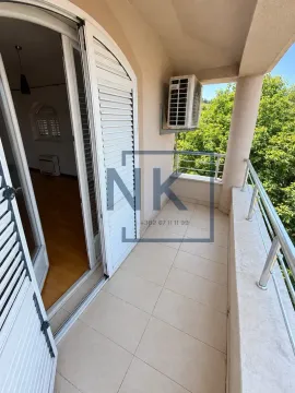 Covered balcony with tiled flooring and a view of greenery. - image 10