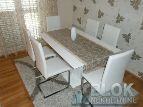 Dining area with a white table and chairs. - image 9