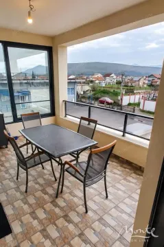 Covered balcony with a table and chairs and a view of the surroundings. - image 14