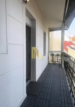 Dugačak natkriveni balkon sa tamnim podom i metalnom ogradom. - image 19